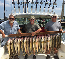 three guys holding a board of fish