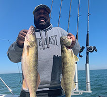 a man holding two walleye
