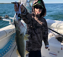 young boy holding a big walleye