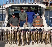 gentlemen standing behind their walleye catch hanging on the board