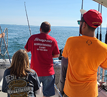 family holding fishing rods and winding in some fish